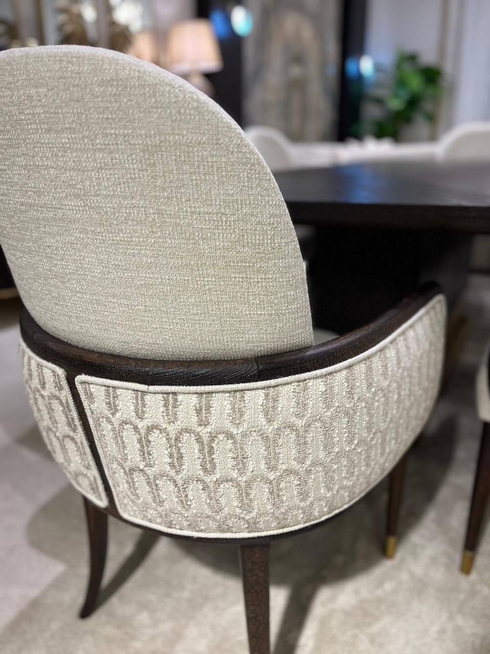 Calm luxury living and dining furniture collection with curved upholstered sofas, dark wood dining table, and elegant sideboard cabinetry.