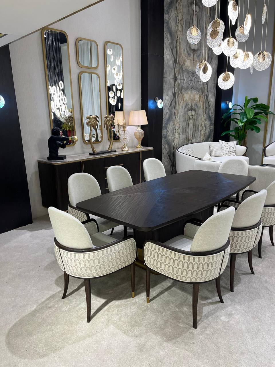 Calm luxury living and dining furniture collection with curved upholstered sofas, dark wood dining table, and elegant sideboard cabinetry.