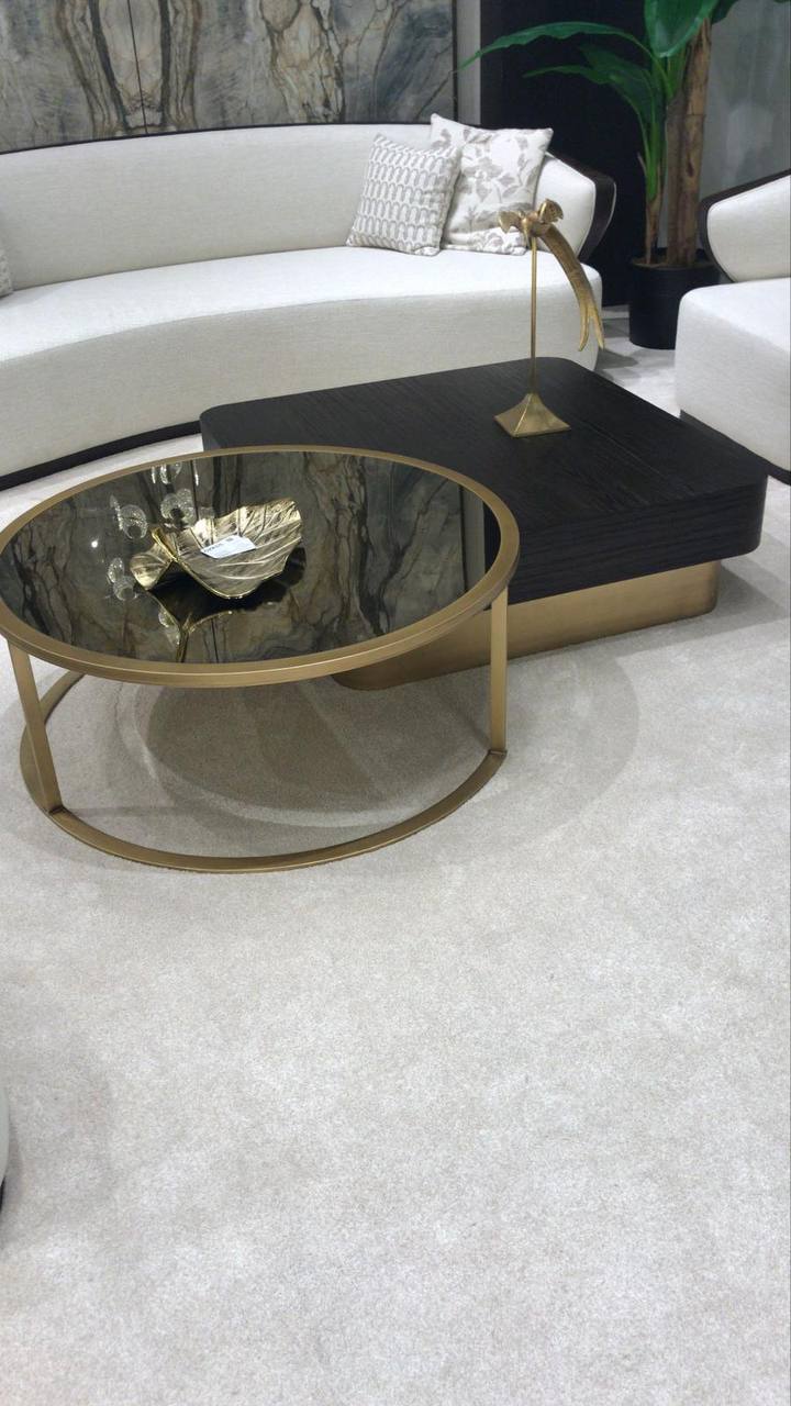 Calm luxury living and dining furniture collection with curved upholstered sofas, dark wood dining table, and elegant sideboard cabinetry.