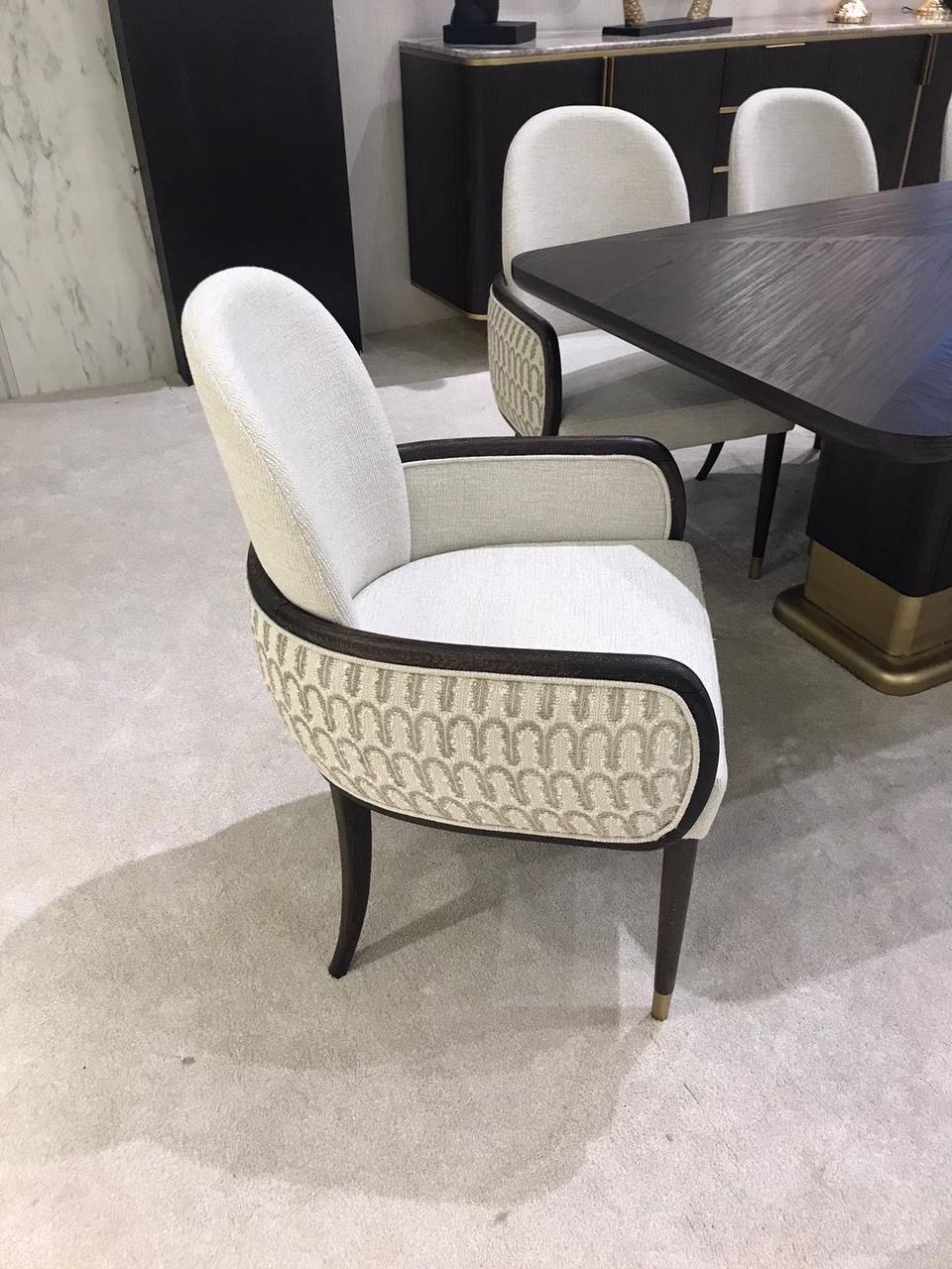 Calm luxury living and dining furniture collection with curved upholstered sofas, dark wood dining table, and elegant sideboard cabinetry.