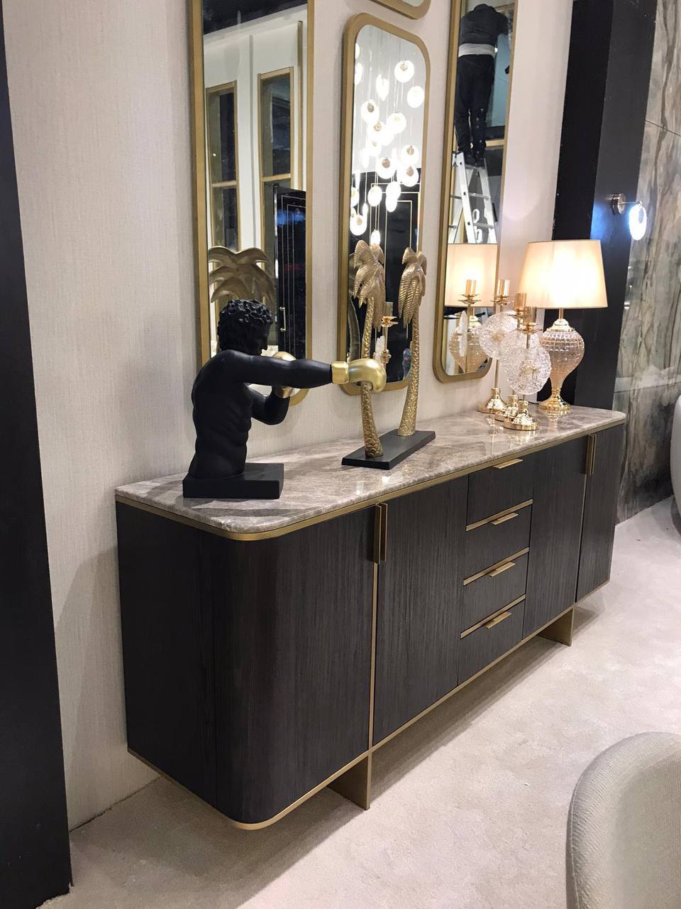 Calm luxury living and dining furniture collection with curved upholstered sofas, dark wood dining table, and elegant sideboard cabinetry.