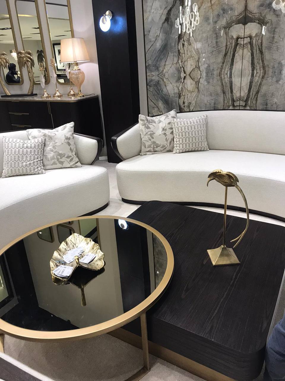 Calm luxury living and dining furniture collection with curved upholstered sofas, dark wood dining table, and elegant sideboard cabinetry.