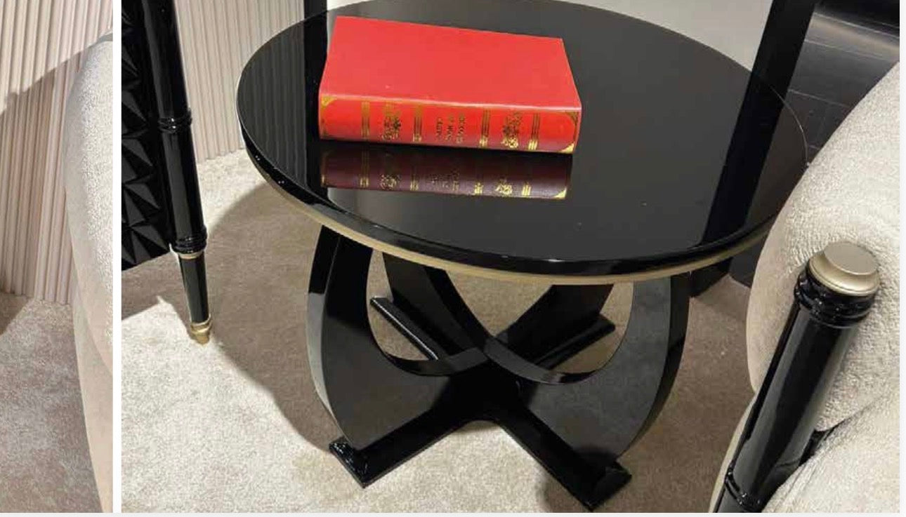 Portrait luxury furniture collection featuring glossy black dining table, sculptural cabinet, and modern curved seating in a contemporary interior.