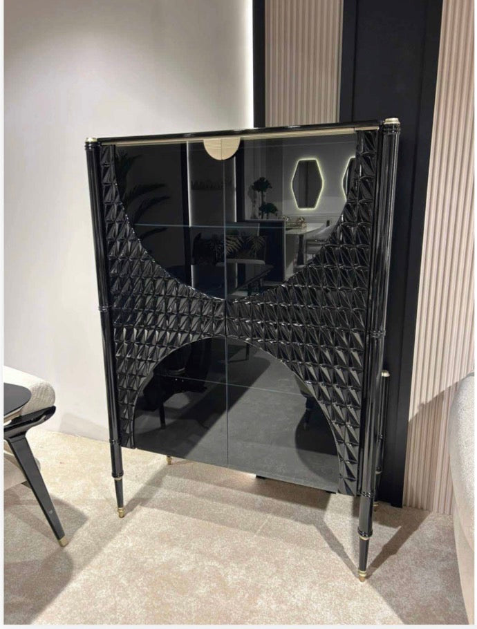 Portrait luxury furniture collection featuring glossy black dining table, sculptural cabinet, and modern curved seating in a contemporary interior.