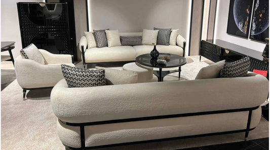 Portrait luxury furniture collection featuring glossy black dining table, sculptural cabinet, and modern curved seating in a contemporary interior.