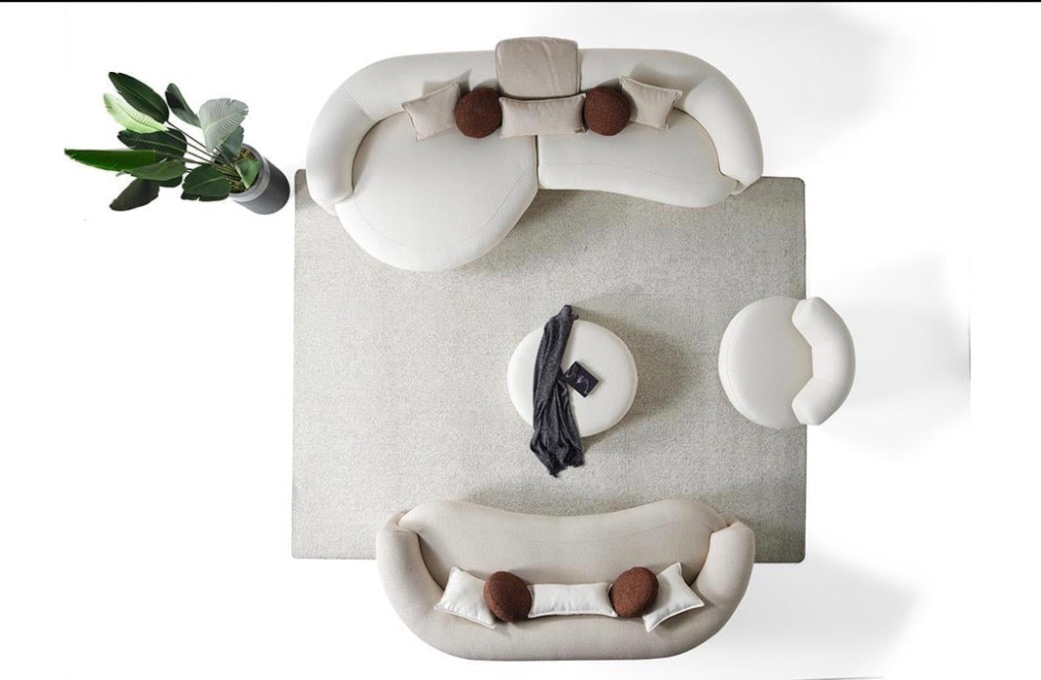 Hush curved sofa furniture collection featuring soft neutral lounge seating and sculptural modern living room design.