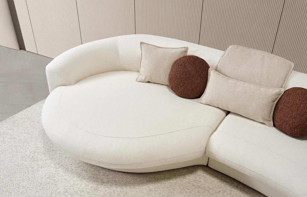 Hush curved sofa furniture collection featuring soft neutral lounge seating and sculptural modern living room design.