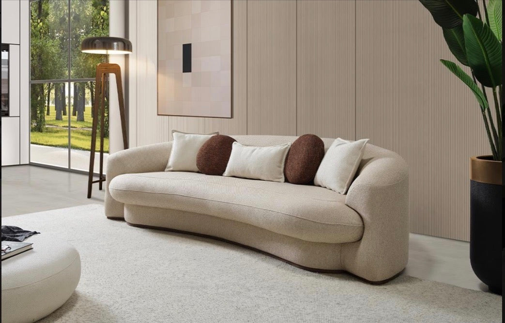 Hush curved sofa furniture collection featuring soft neutral lounge seating and sculptural modern living room design.