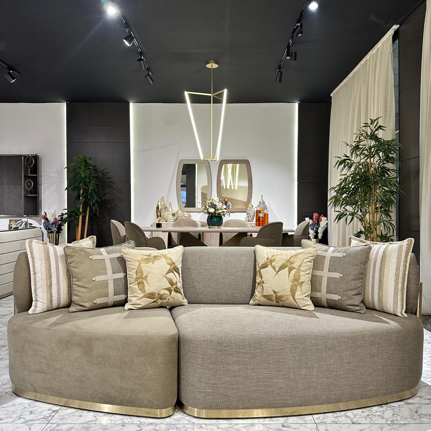 Sonata luxury furniture collection featuring curved modern sofas, sculptural accent chairs, and contemporary dining table in warm neutral tones.