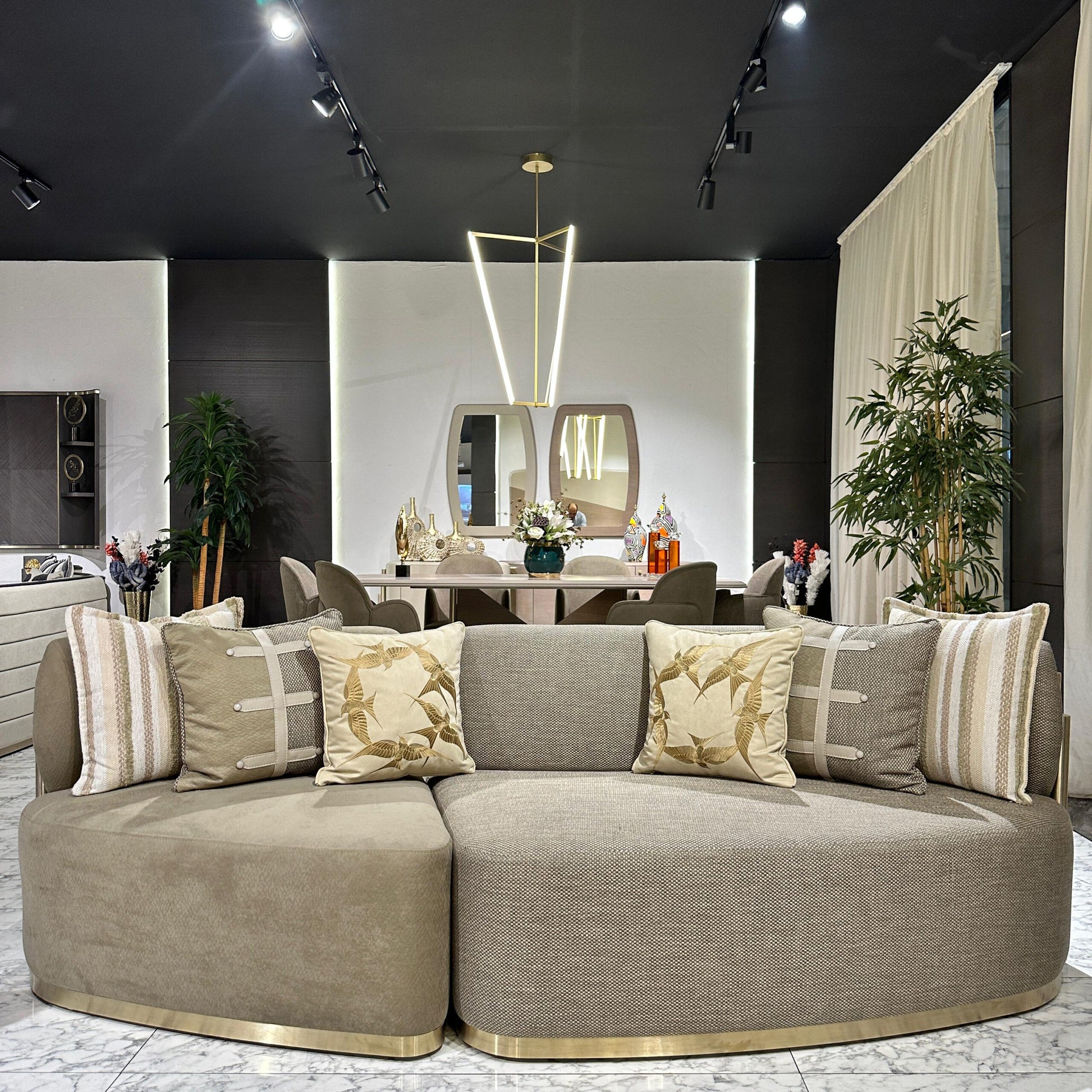 Sonata luxury furniture collection featuring curved modern sofas, sculptural accent chairs, and contemporary dining table in warm neutral tones.