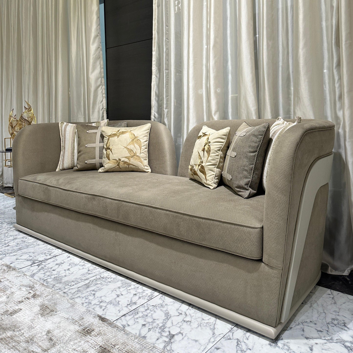 Sonata luxury furniture collection featuring curved modern sofas, sculptural accent chairs, and contemporary dining table in warm neutral tones.