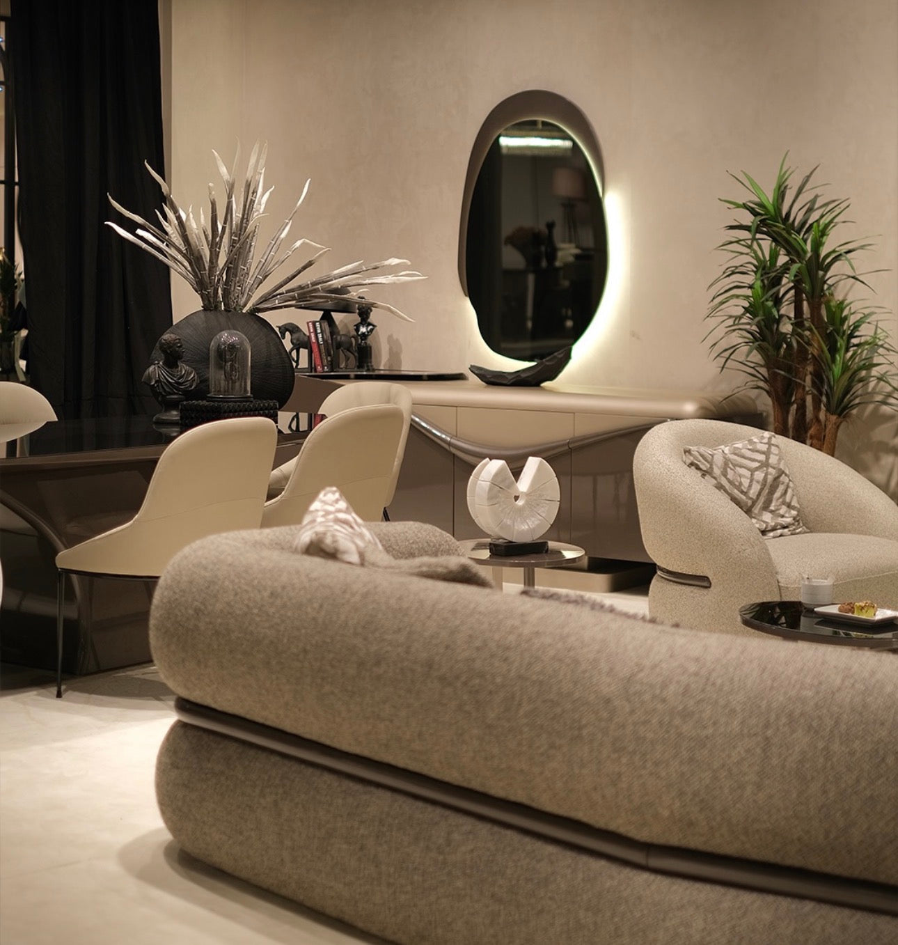 Regal luxury furniture collection featuring curved sofa seating, modern dining table with upholstered chairs, and contemporary living room design.