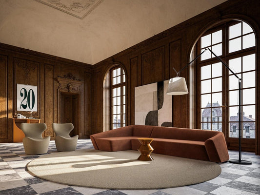 Overtime luxury furniture collection featuring curved sofa, sculptural lounge chairs, modern coffee table, and classic architectural interior setting.