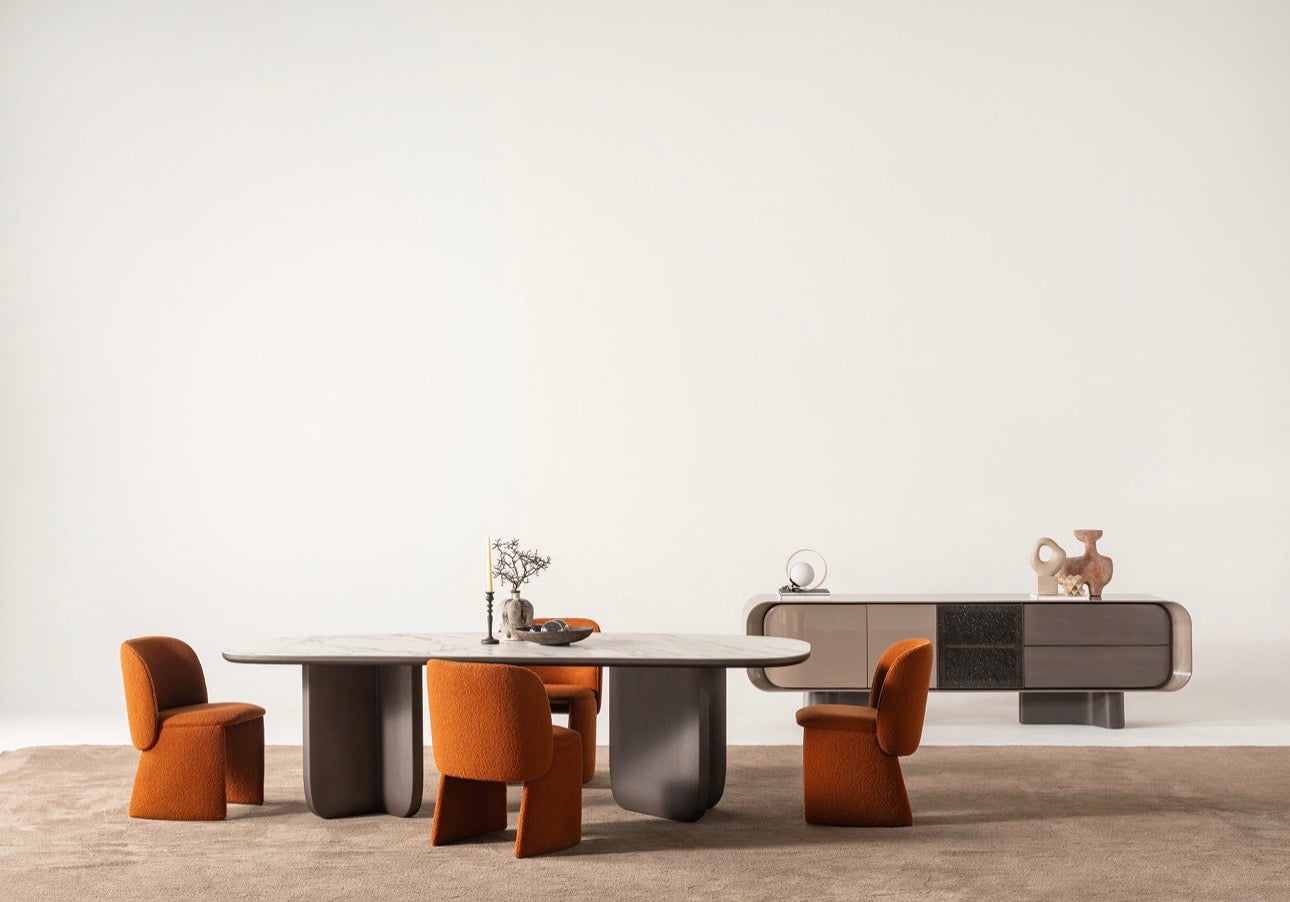 Urbane modern luxury furniture collection featuring sculptural dining table, curved bedroom furniture, and terracotta lacquer accents.