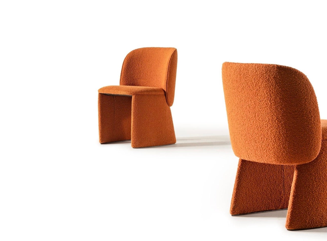 Urbane modern luxury furniture collection featuring sculptural dining table, curved bedroom furniture, and terracotta lacquer accents.