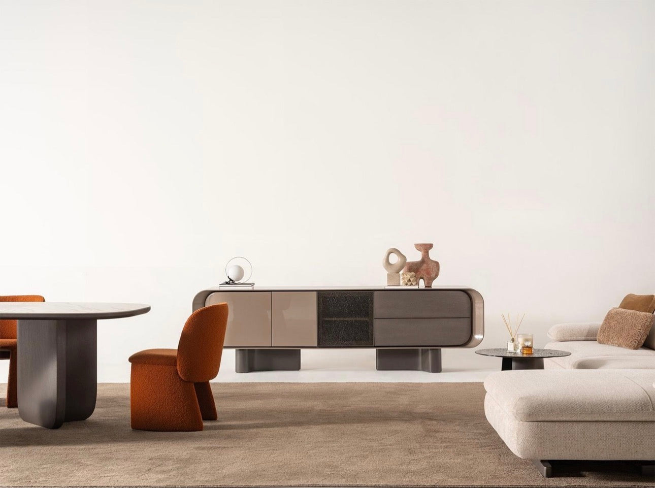 Urbane modern luxury furniture collection featuring sculptural dining table, curved bedroom furniture, and terracotta lacquer accents.