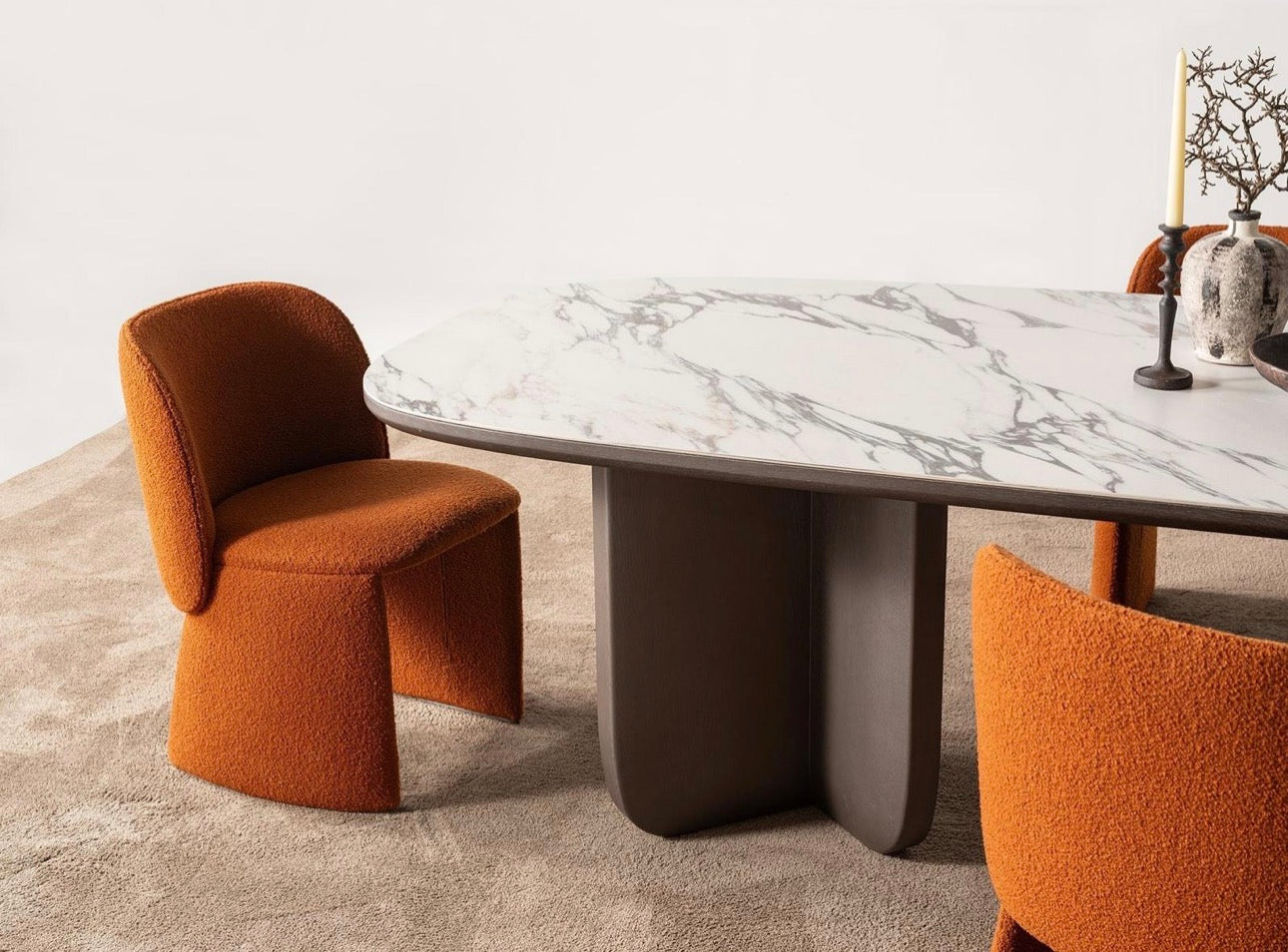 Urbane modern luxury furniture collection featuring sculptural dining table, curved bedroom furniture, and terracotta lacquer accents.