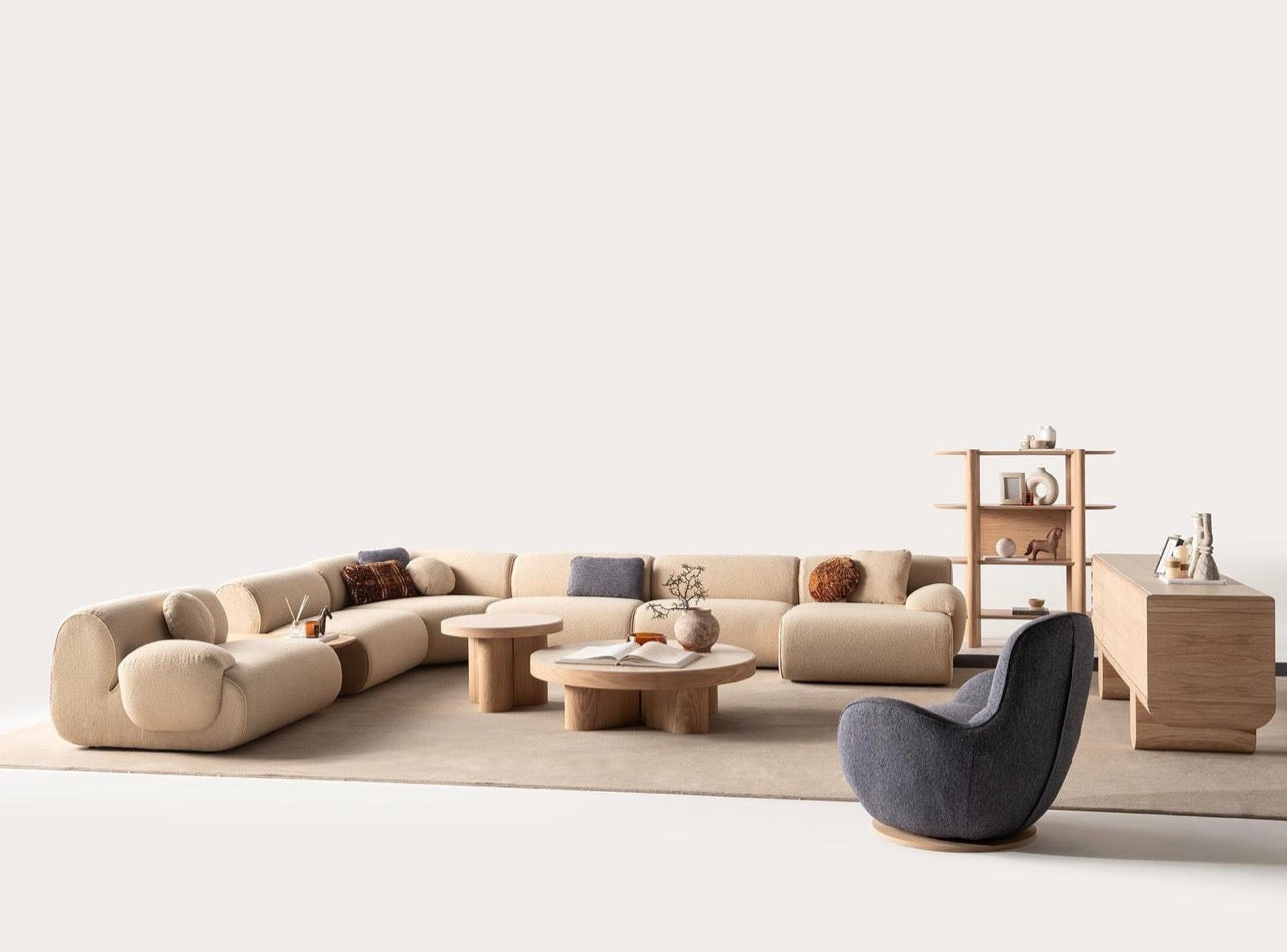 Lumen modern organic living room collection with curved sectional sofa, natural wood coffee tables, and warm minimalist interior design.