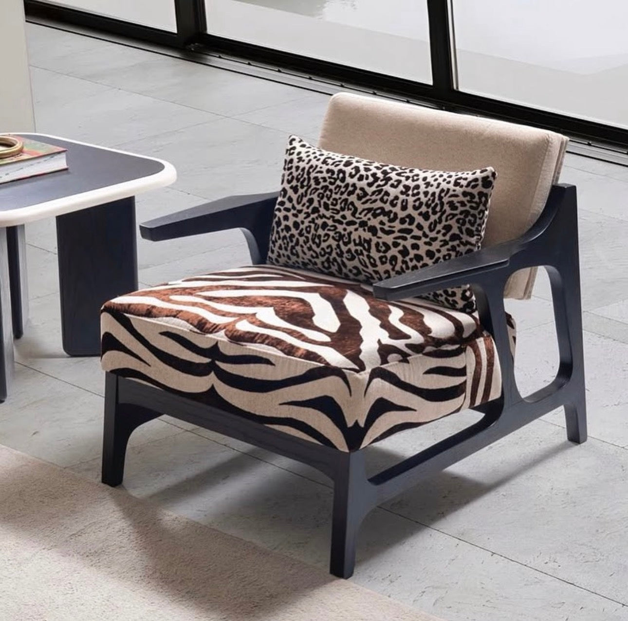 Reverie luxury furniture collection featuring sculptural sofa seating, zebra patterned accent chairs, modern dining table, and contemporary living room design.