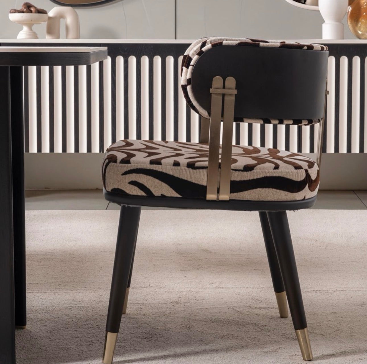 Reverie luxury furniture collection featuring sculptural sofa seating, zebra patterned accent chairs, modern dining table, and contemporary living room design.