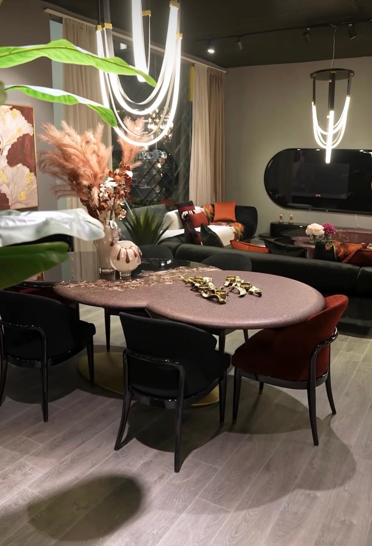 Noir luxury furniture collection with black velvet sofas, copper dining table, sculptural lighting, and dramatic modern interior styling.