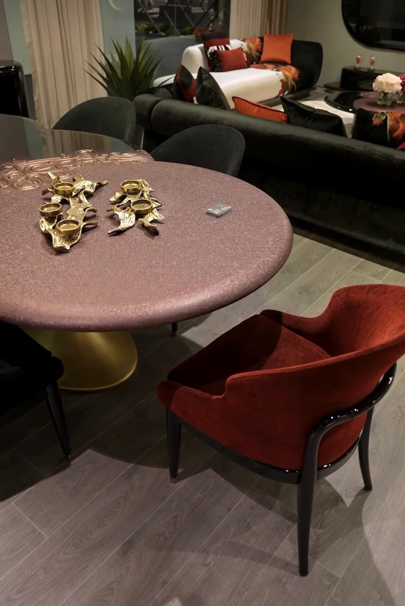 Noir luxury furniture collection with black velvet sofas, copper dining table, sculptural lighting, and dramatic modern interior styling.