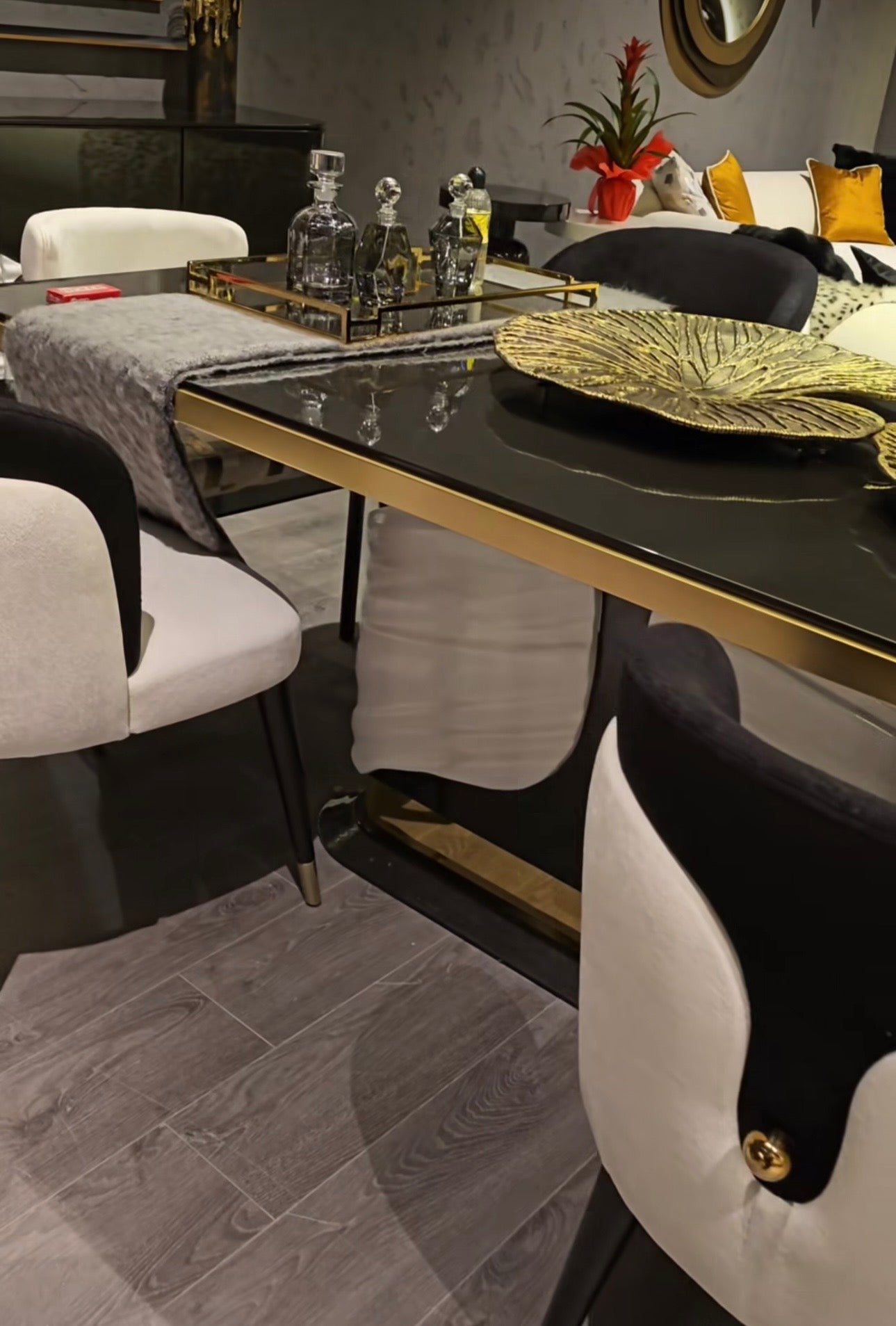 Monochrome modern luxury furniture collection featuring ivory curved sofa, black lacquer tables, and gold accent dining furniture.