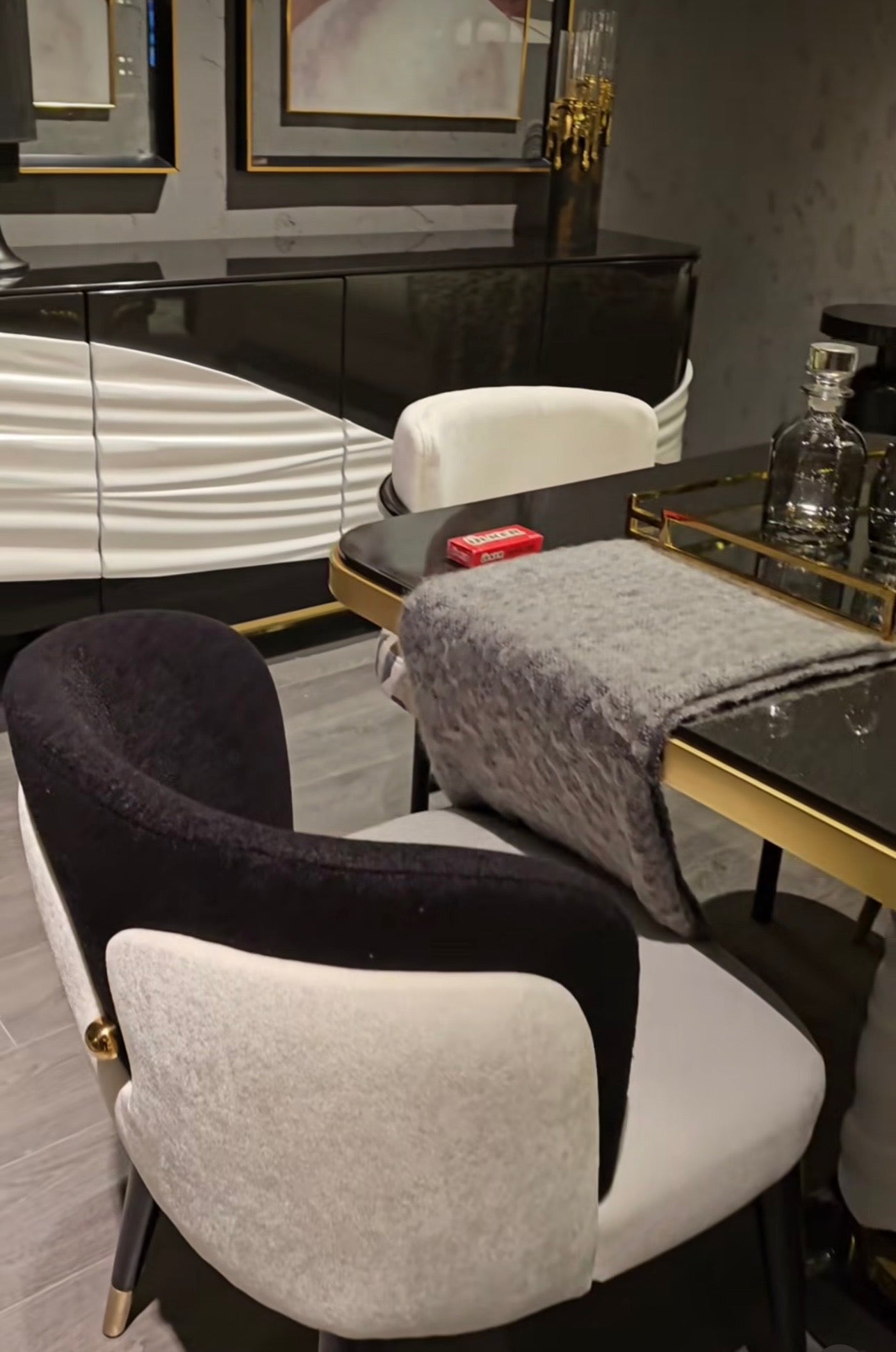 Monochrome modern luxury furniture collection featuring ivory curved sofa, black lacquer tables, and gold accent dining furniture.