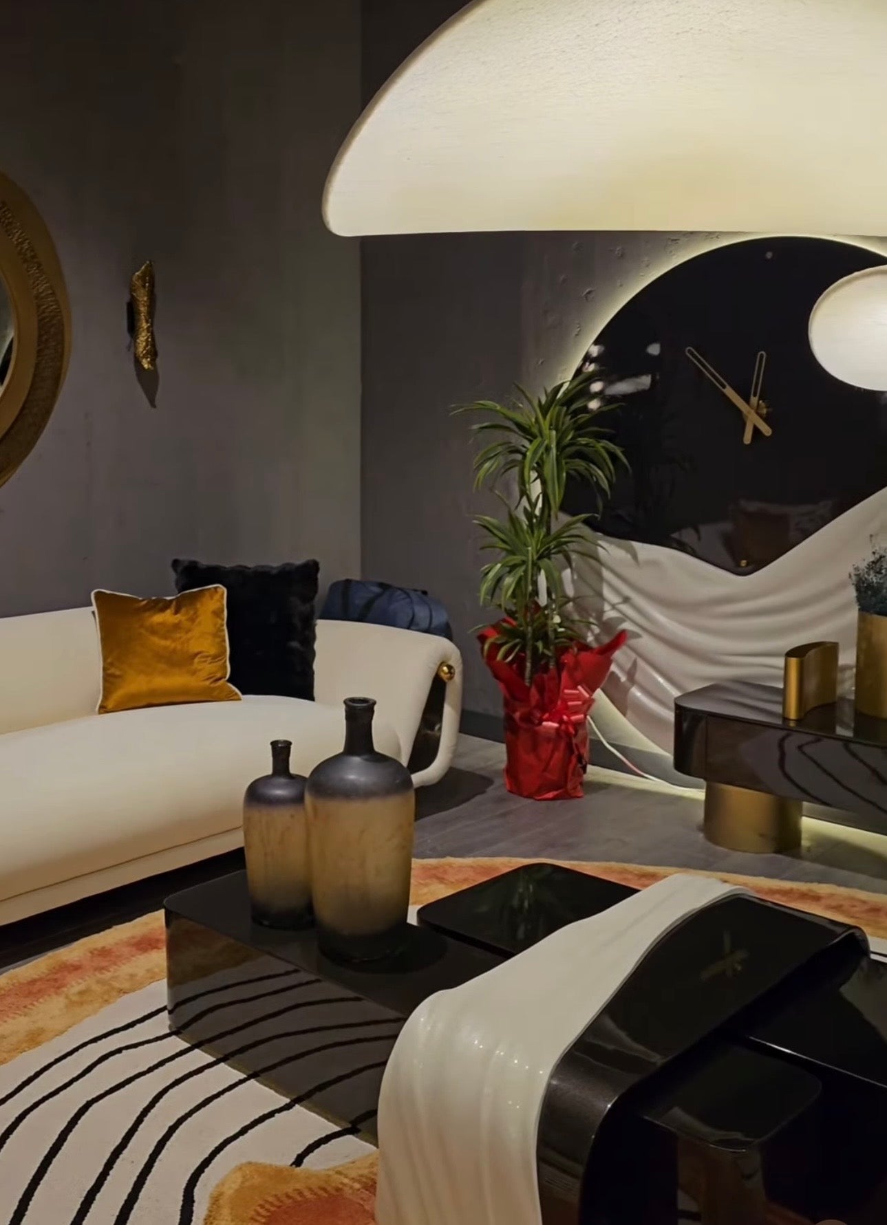 Monochrome modern luxury furniture collection featuring ivory curved sofa, black lacquer tables, and gold accent dining furniture.