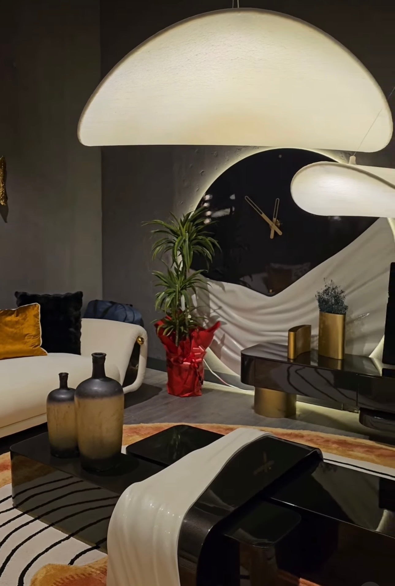 Monochrome modern luxury furniture collection featuring ivory curved sofa, black lacquer tables, and gold accent dining furniture.