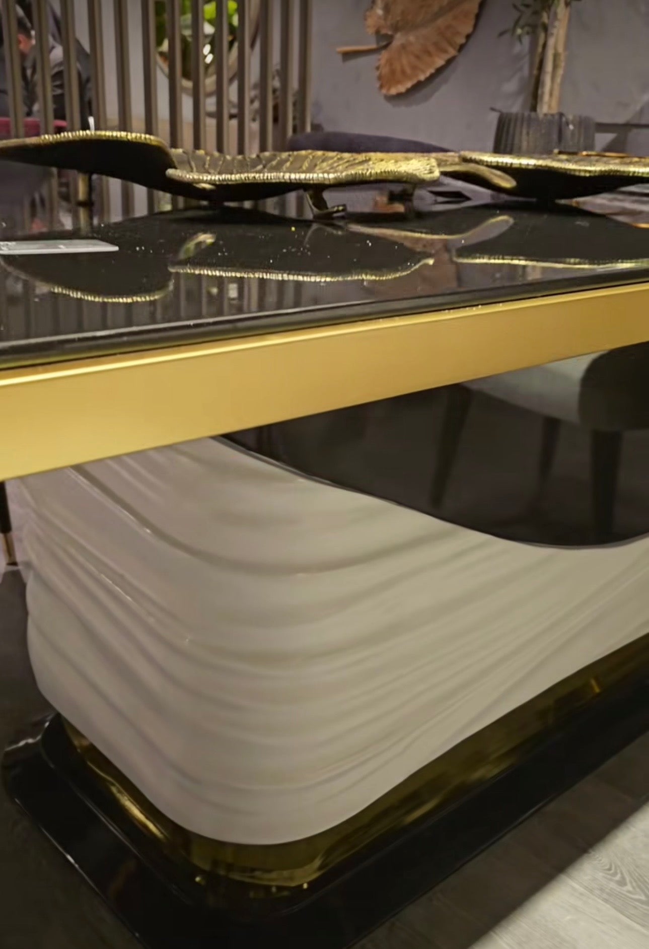 Monochrome modern luxury furniture collection featuring ivory curved sofa, black lacquer tables, and gold accent dining furniture.