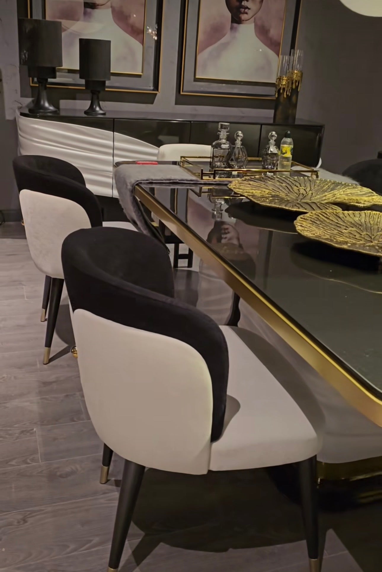 Monochrome modern luxury furniture collection featuring ivory curved sofa, black lacquer tables, and gold accent dining furniture.