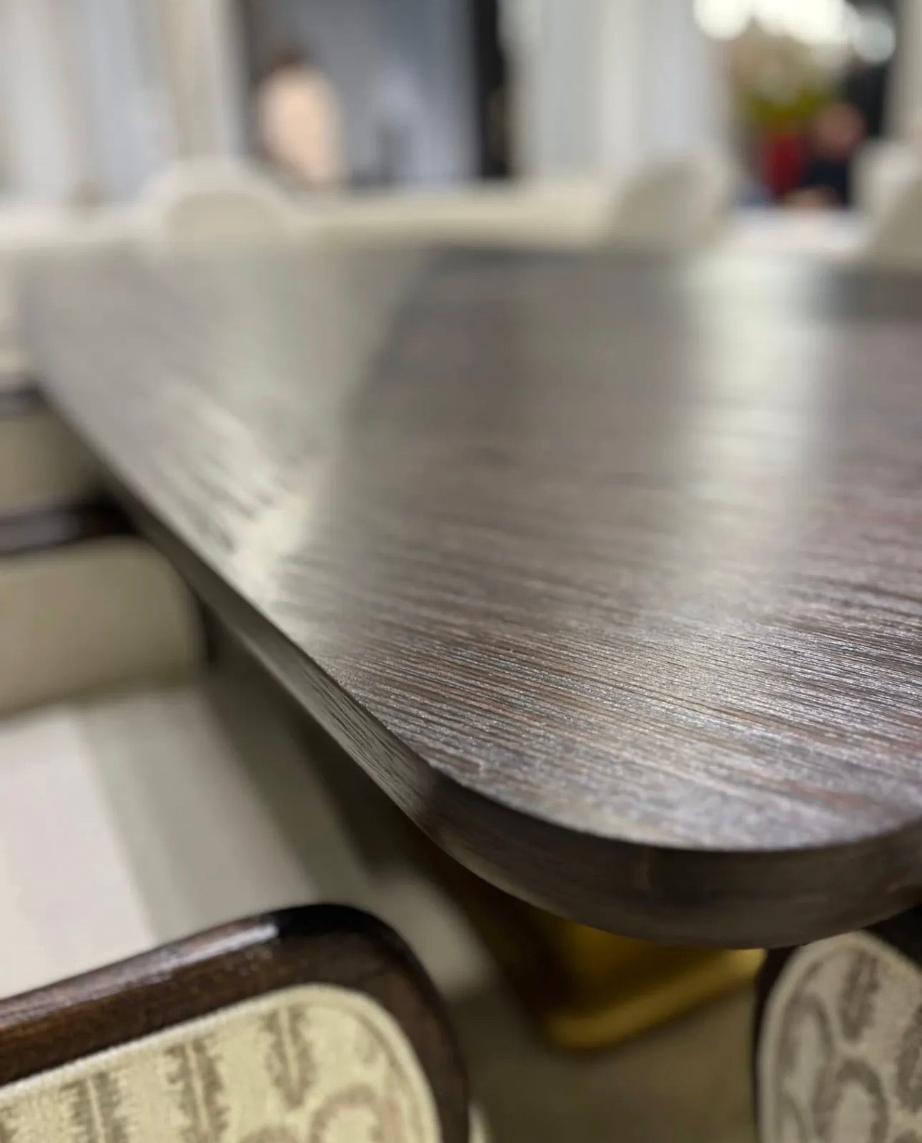 Calm luxury living and dining furniture collection with curved upholstered sofas, dark wood dining table, and elegant sideboard cabinetry.