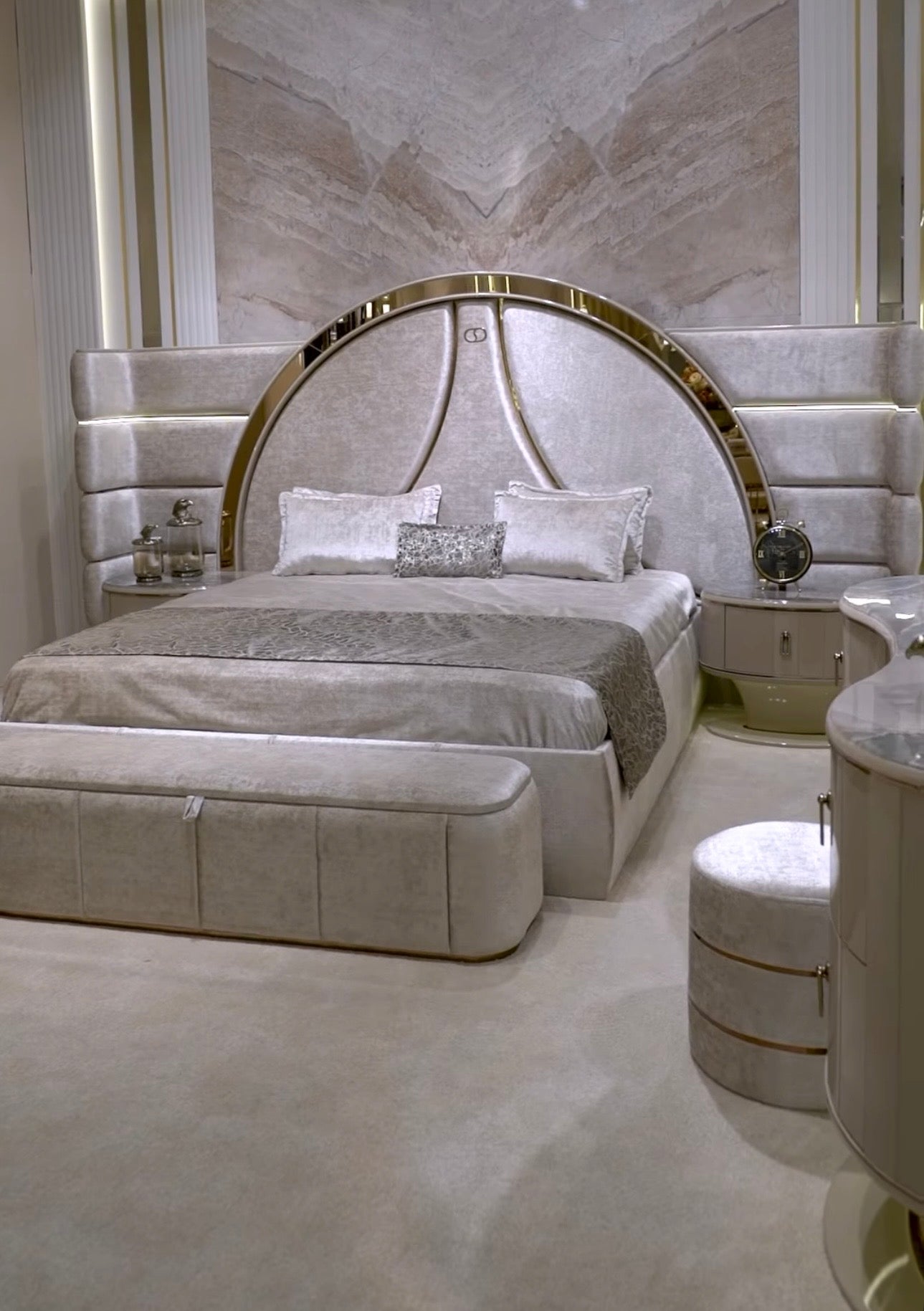 Crown luxury modern bedroom furniture collection with arched statement bed, marble dining table, mirrored wardrobe, and sculptural vanity.