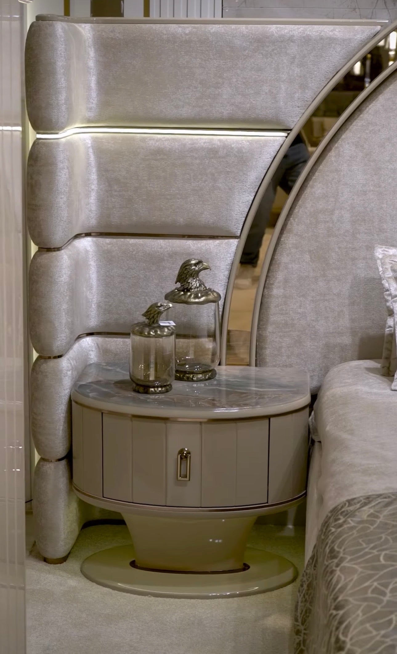 Crown luxury modern bedroom furniture collection with arched statement bed, marble dining table, mirrored wardrobe, and sculptural vanity.