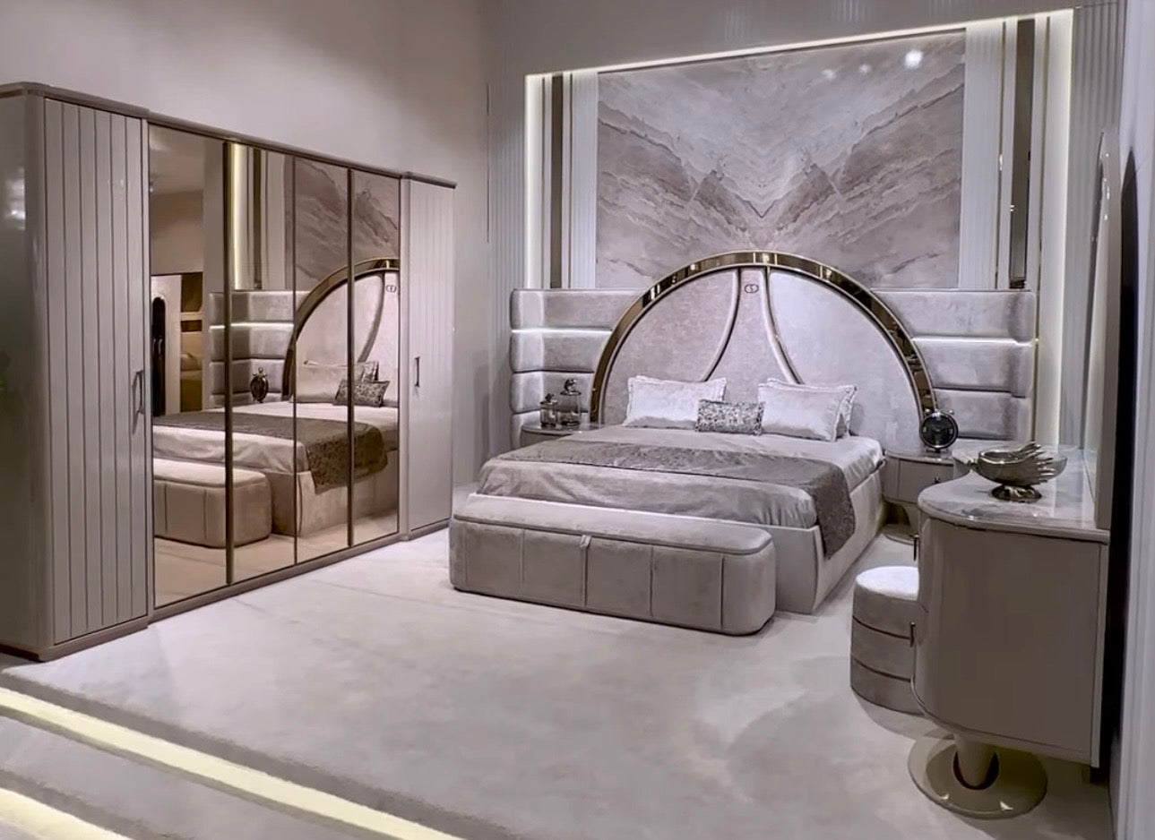 Crown luxury modern bedroom furniture collection with arched statement bed, marble dining table, mirrored wardrobe, and sculptural vanity.