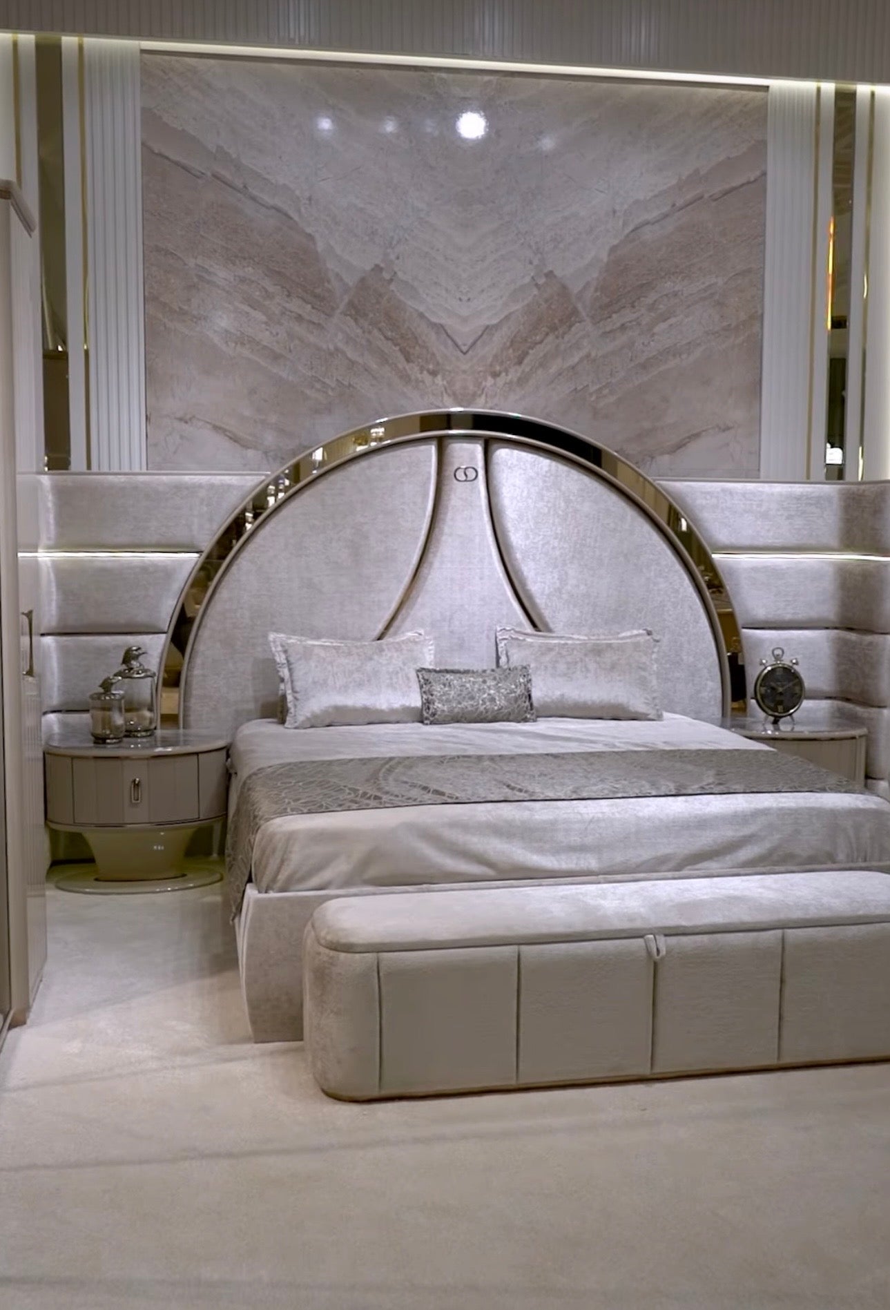 Crown luxury modern bedroom furniture collection with arched statement bed, marble dining table, mirrored wardrobe, and sculptural vanity.