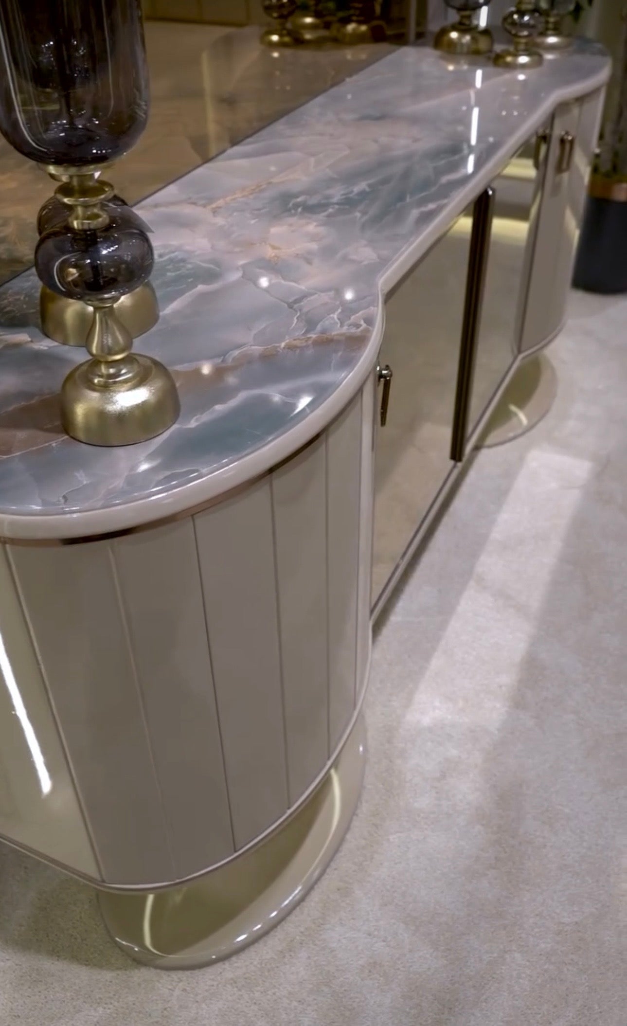 Crown luxury modern bedroom furniture collection with arched statement bed, marble dining table, mirrored wardrobe, and sculptural vanity.