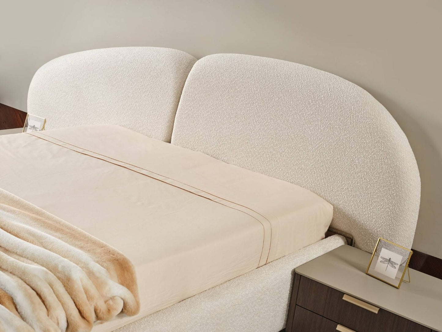 Terrae modern luxury bedroom collection featuring upholstered bed, sculptural mirror vanity, and warm wood bedside tables in a serene minimalist space.