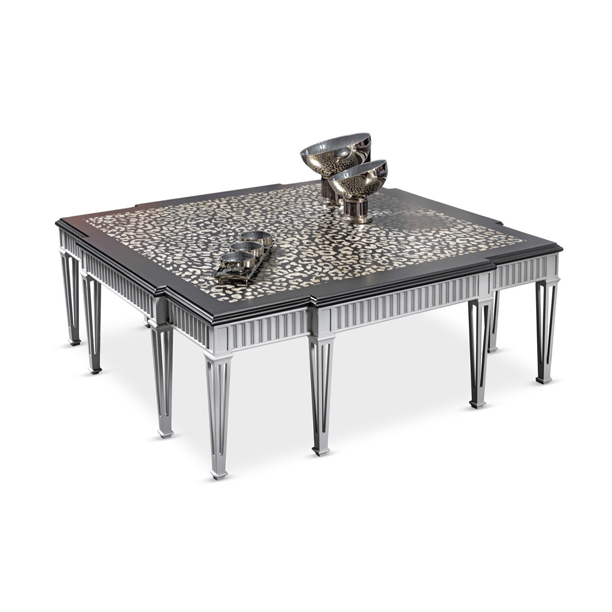 Panthera luxury furniture collection featuring statement sofa, sculptural coffee table, pedestal table, and modern shelving in dark finishes.