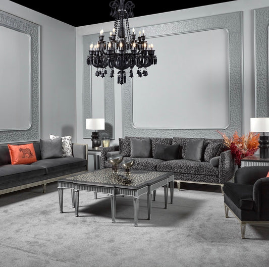 Panthera luxury furniture collection featuring statement sofa, sculptural coffee table, pedestal table, and modern shelving in dark finishes.