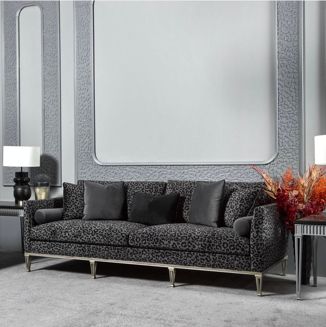 Panthera luxury furniture collection featuring statement sofa, sculptural coffee table, pedestal table, and modern shelving in dark finishes.