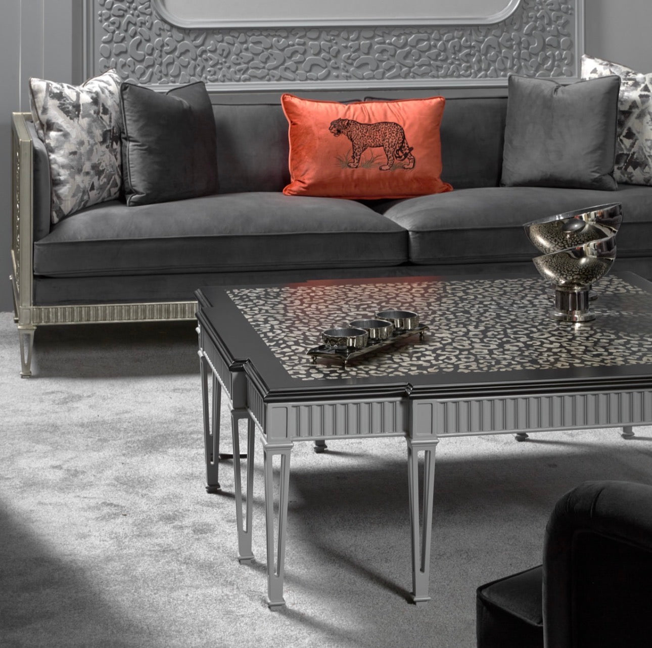 Panthera luxury furniture collection featuring statement sofa, sculptural coffee table, pedestal table, and modern shelving in dark finishes.