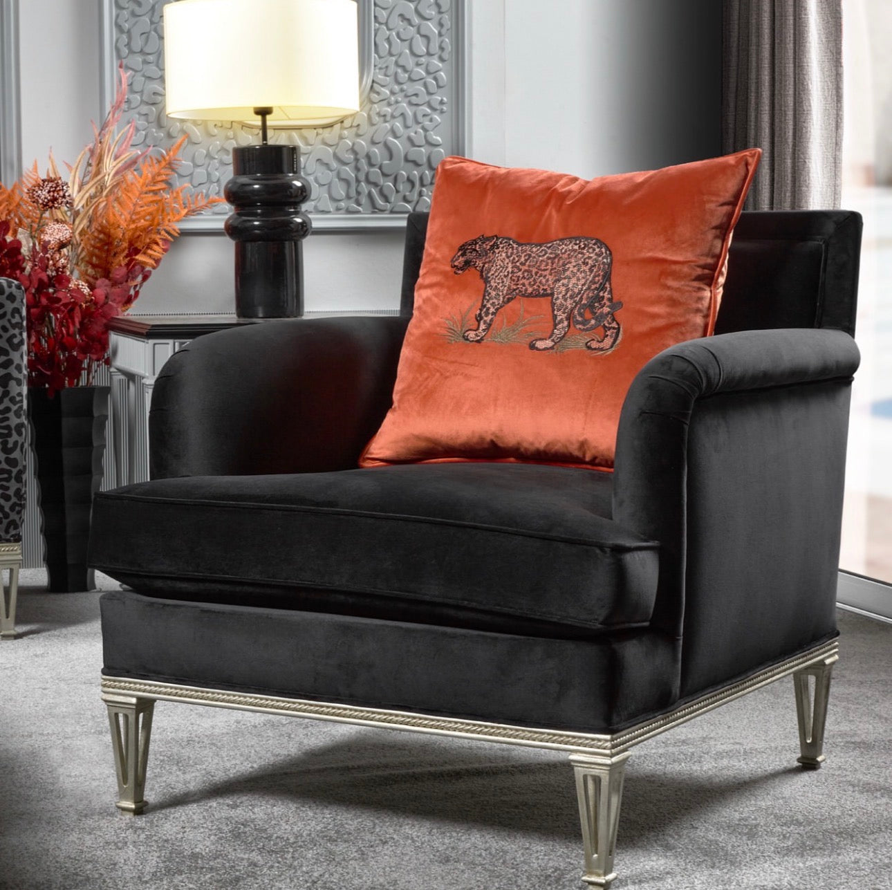 Panthera luxury furniture collection featuring statement sofa, sculptural coffee table, pedestal table, and modern shelving in dark finishes.