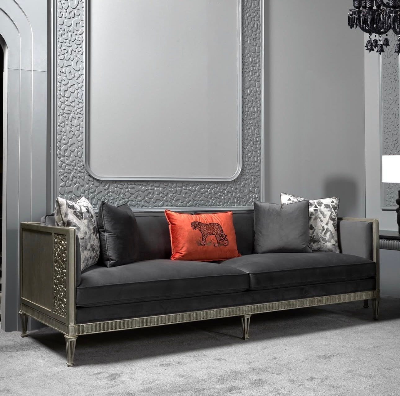 Panthera luxury furniture collection featuring statement sofa, sculptural coffee table, pedestal table, and modern shelving in dark finishes.