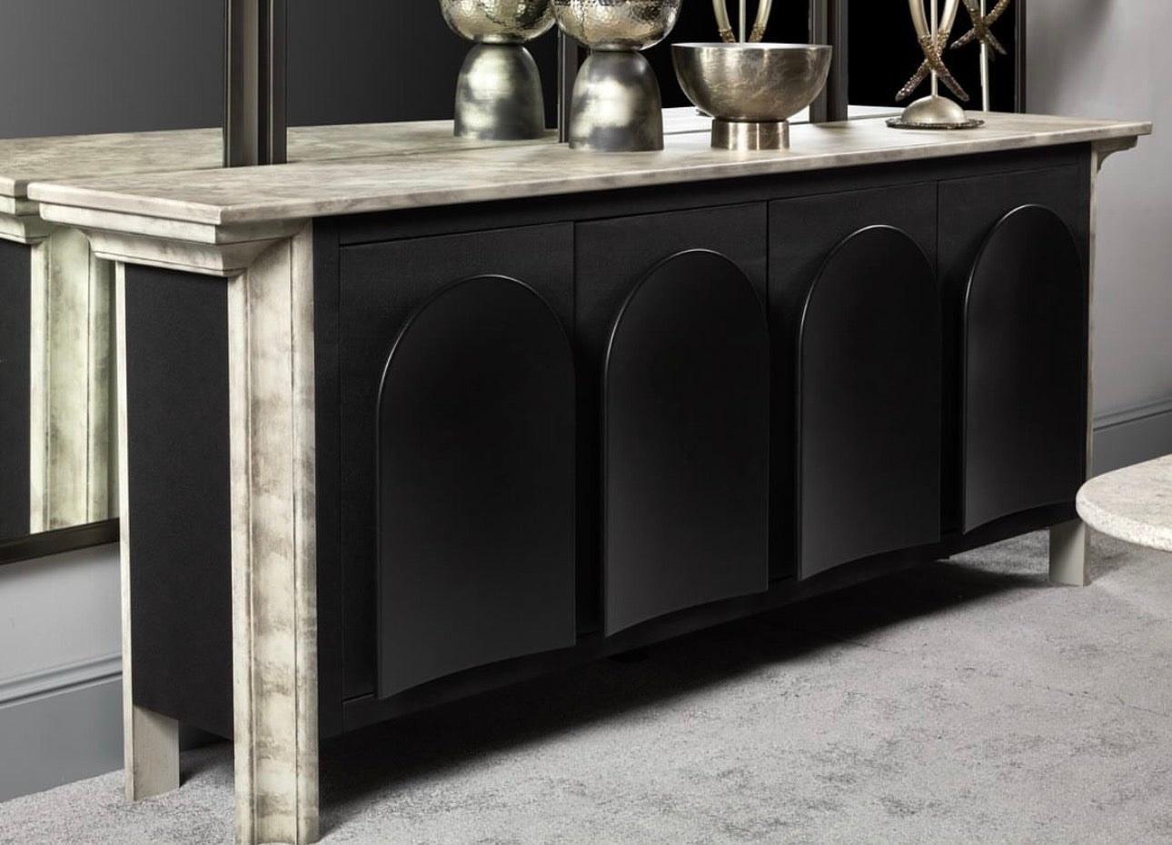 Panthera luxury furniture collection featuring statement sofa, sculptural coffee table, pedestal table, and modern shelving in dark finishes.