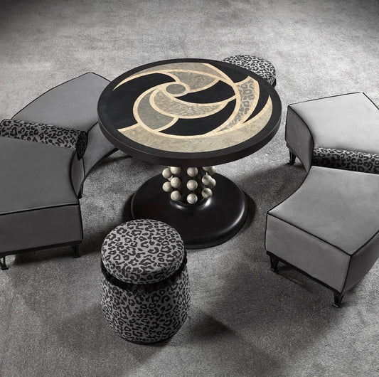 Panthera luxury furniture collection featuring statement sofa, sculptural coffee table, pedestal table, and modern shelving in dark finishes.