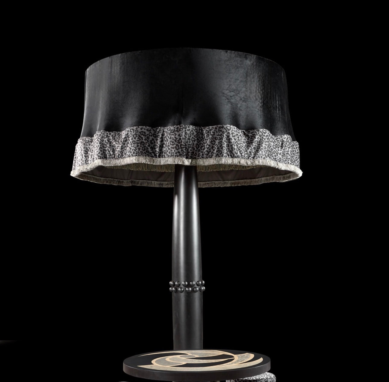 Panthera luxury furniture collection featuring statement sofa, sculptural coffee table, pedestal table, and modern shelving in dark finishes.