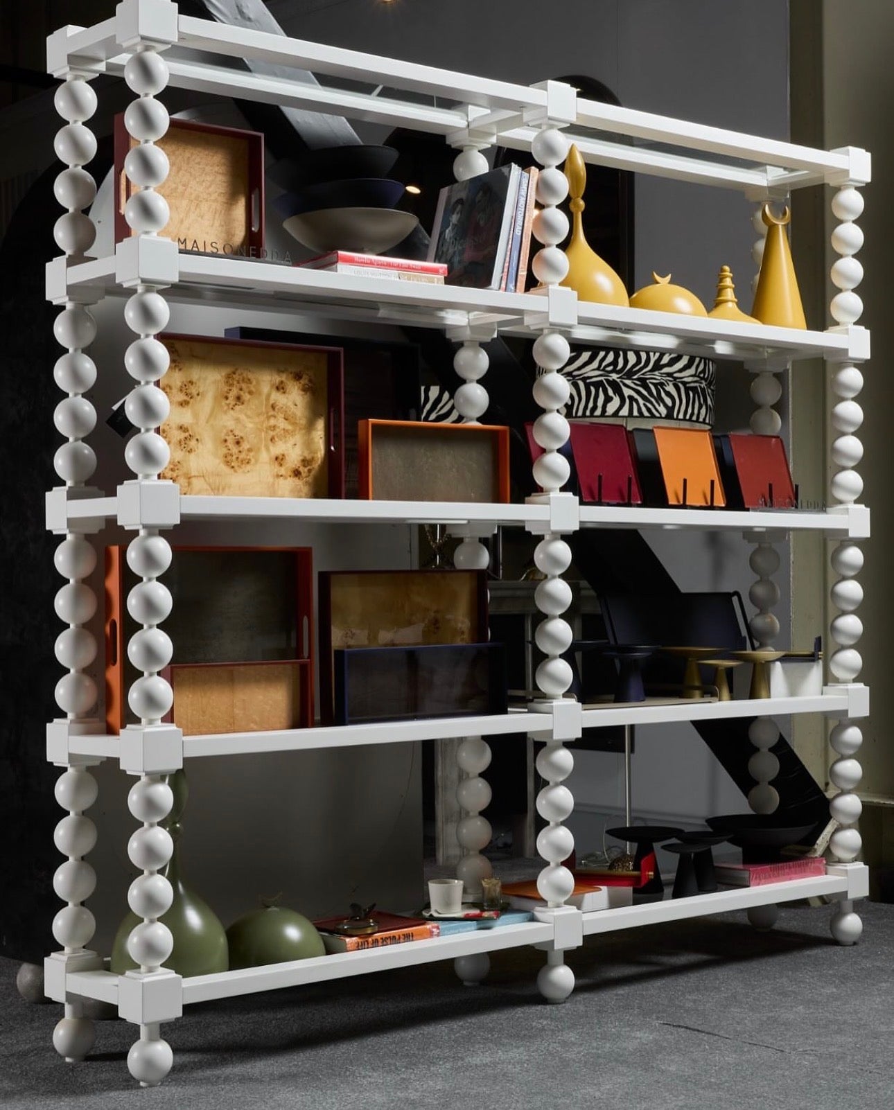 Panthera luxury furniture collection featuring statement sofa, sculptural coffee table, pedestal table, and modern shelving in dark finishes.