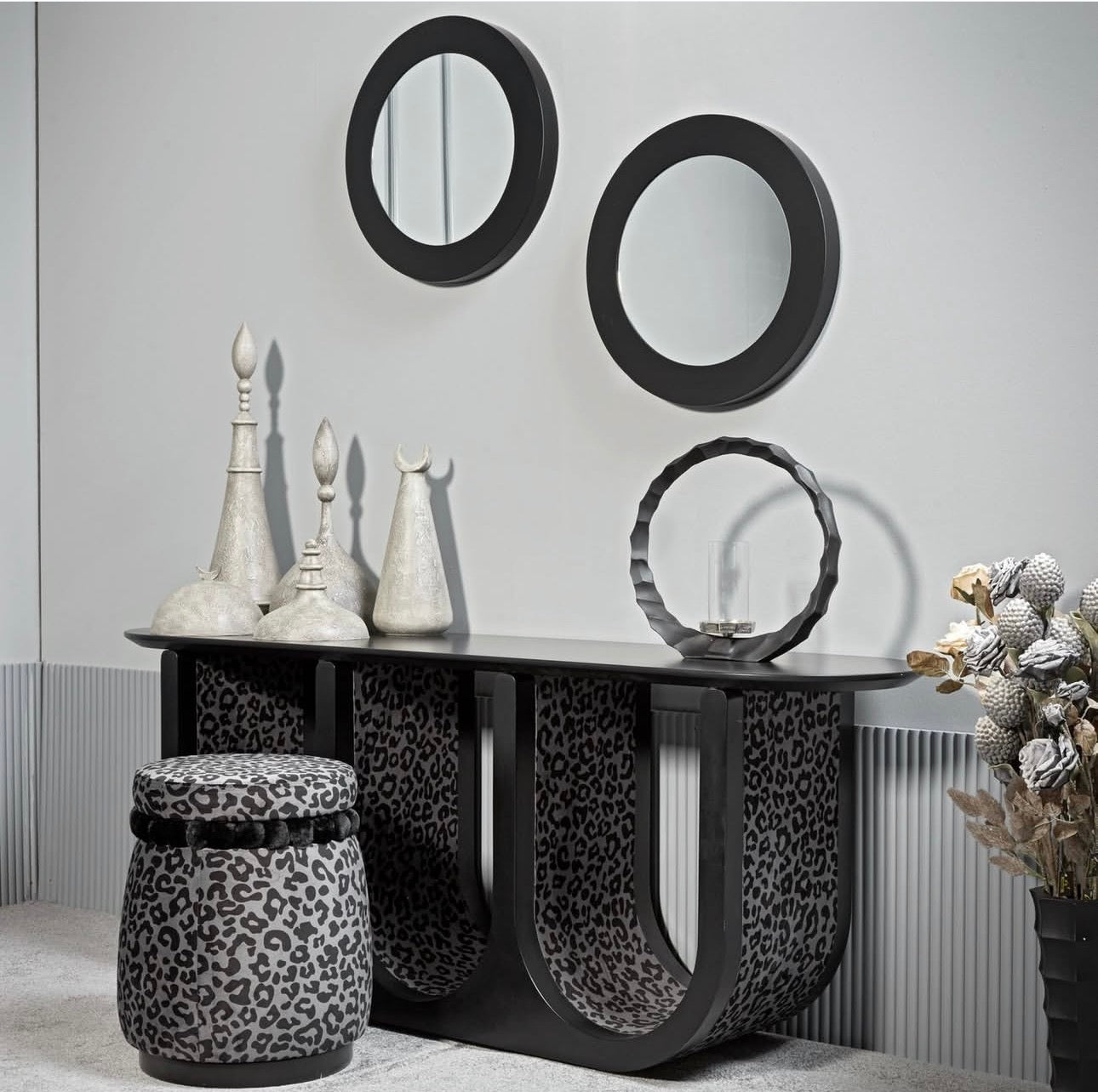 Panthera luxury furniture collection featuring statement sofa, sculptural coffee table, pedestal table, and modern shelving in dark finishes.